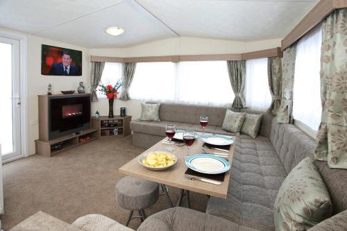 a living room with a couch and a table at Roselands Caravan Park in St Just