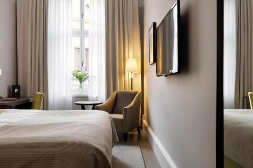 a hotel room with two beds and a tv on the wall at Elite Grand Hotel Gävle in Gävle