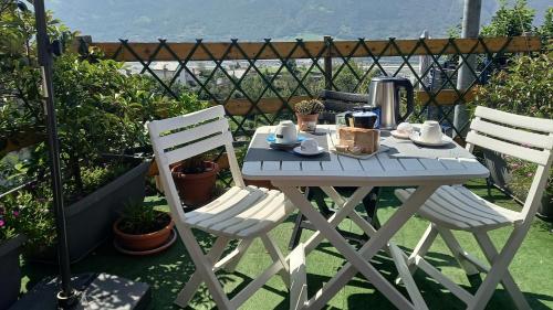 a picnic table with two chairs and a coffee maker on it at la Casa di FrAnto Appartamento in Saint-Christophe