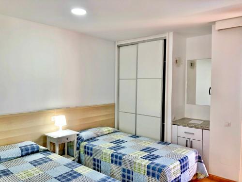 a room with two beds and a table and a kitchen at Don Gregorio in Playa del Ingles