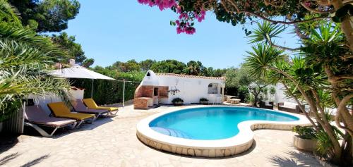 a swimming pool in a yard with chairs and a house at Casa Del Sol in L'Ametlla de Mar