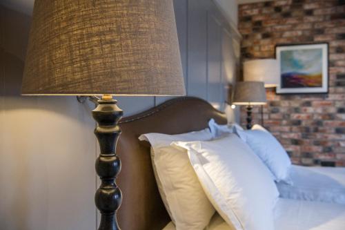 a lamp sitting next to a bed with pillows at Sandburn Hall in York