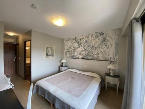 a bedroom with a bed and a wall mural at Hôtel Le Colombier in Moustiers-Sainte-Marie