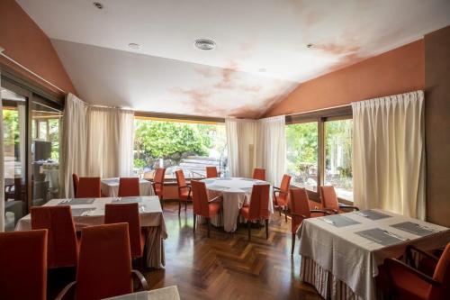 a dining room with tables and chairs and windows at Hotel Soho Boutique Vistahermosa in El Puerto de Santa María