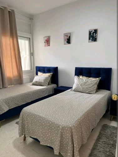 a bedroom with two beds and a window at Residence Mariem in Ariana