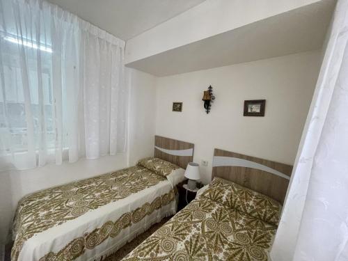 sypialnia z dwoma łóżkami i oknem w obiekcie Eleven Caballos Apartment w mieście Benidorm