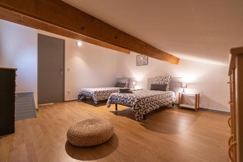 un salon avec deux lits et une table dans l'établissement Besoin de vous ressourcer Maison 3ch, à Vallon-Pont-dʼArc