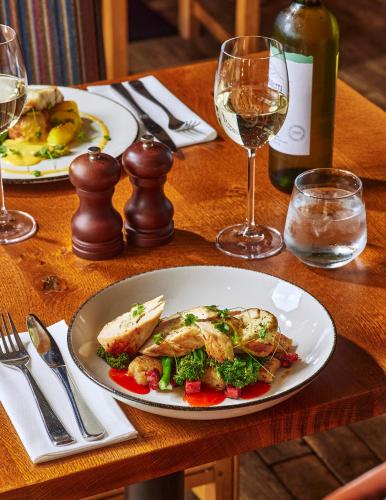 a table with a plate of food and a glass of wine at Sandburn Hall in York
