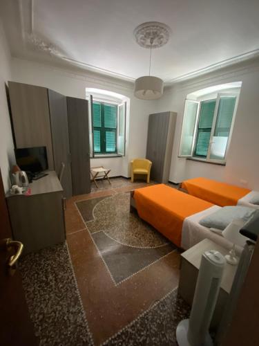 - une chambre avec un lit orange et une télévision dans l'établissement ALBERGO LOCANDA DIANA, à Gênes