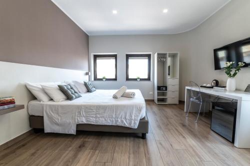 a bedroom with a large bed and a desk at Ruggero Settimo - Room & Suite in Palermo