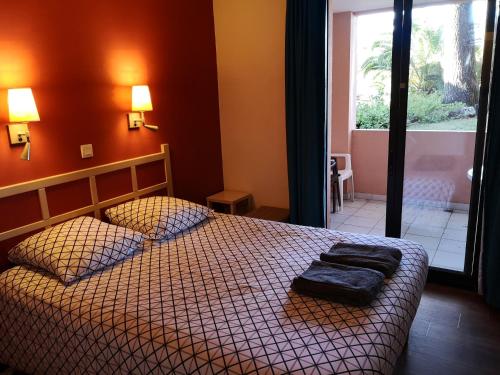 une chambre avec un lit avec deux oreillers dessus dans l'établissement Flo & Rose Azur - Duplex vue mer terrasses piscine jardins parking, à Cannes