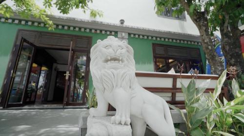 a statue of a lion sitting in front of a building at Chu Hotel in Da Nang