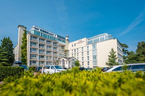 a large building with cars parked in a parking lot at Rugard Thermal Strandhotel in Binz