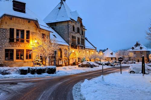 a city street with snow covered buildings and cars parked at Nid douillet 2ou4 p à St Pierre de Chartreuse in Saint-Pierre-de-Chartreuse