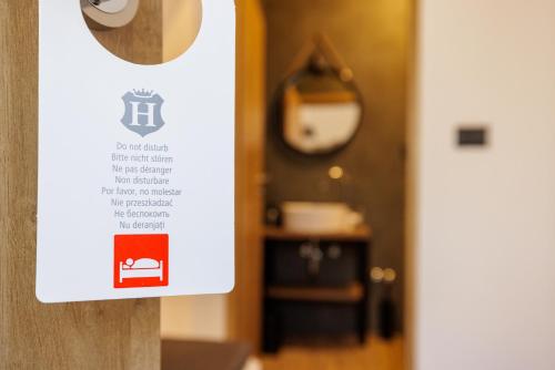 a sign on a door with a room in the background at Rooms Lišnić in Osijek