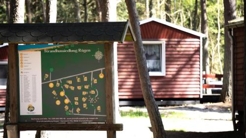 a sign in front of a small building at Strandhussiedlung Rügen in Dranske