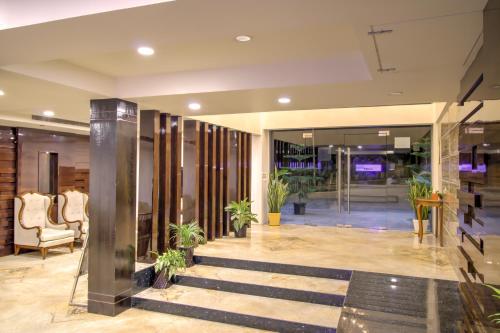 a lobby with stairs and plants in a building at Cygnett Inn Trendz in Itānagar