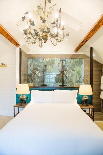 a bedroom with a large bed with a chandelier at The Hotel Chester in Chester