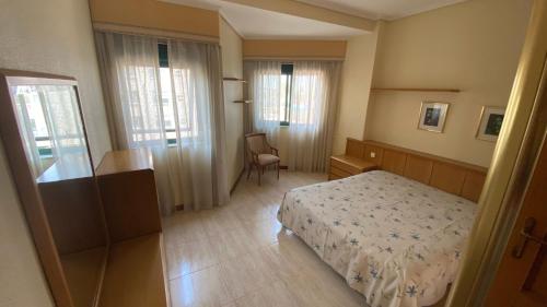 a bedroom with a bed and a chair in it at Apartamento Playa Samil in Vigo