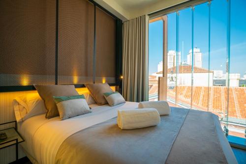 a bedroom with a large bed with a large window at Akeah Hotel Gran Vía in Madrid