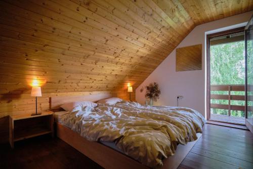 a large bed in a room with a wooden ceiling at Holiday House Podhamer Marijan private Wellness in Ljutomer