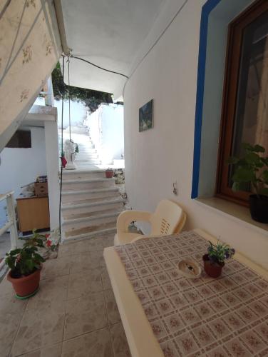a room with a table and chairs and a staircase at Summer room in Himare