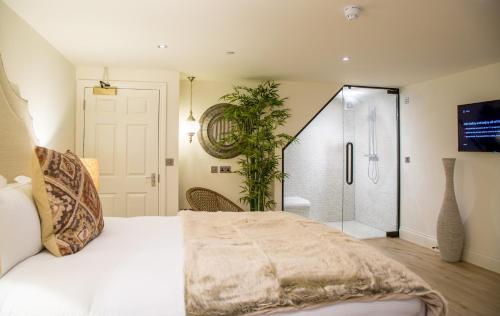 a bedroom with a large bed and a shower at The Hotel Chester in Chester