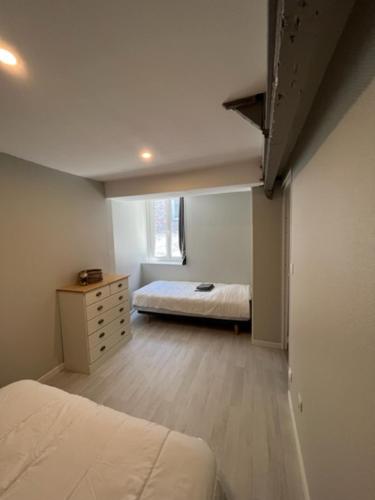 a bedroom with a bed and a dresser in a room at La Maison Bleue, proche de tout in Le Tréport