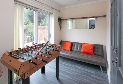 uma sala de estar com uma mesa de matraquilhos e um sofá em The Cresent WV1 - 3 Bedroom House, Table Soccer, Parking, Garden em Monmore Green