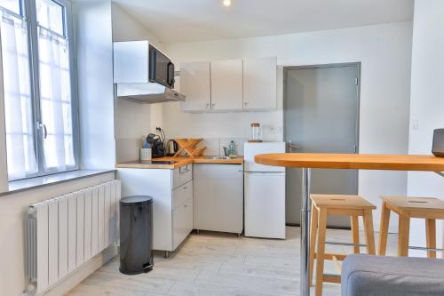 - une cuisine avec des appareils blancs et une table en bois dans l'établissement LE P'TI COGNAC #Charente #CentreVille, à Cognac