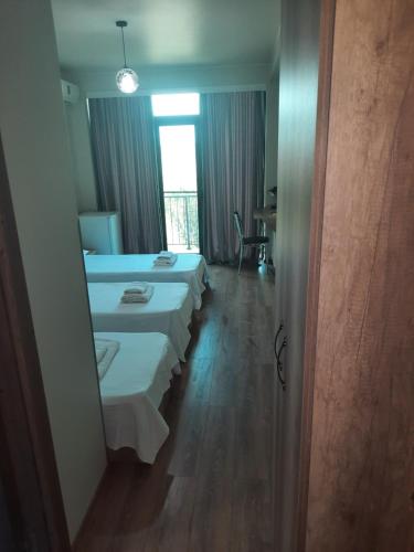 a row of beds in a room with a mirror at Delta Hotel in Ureki