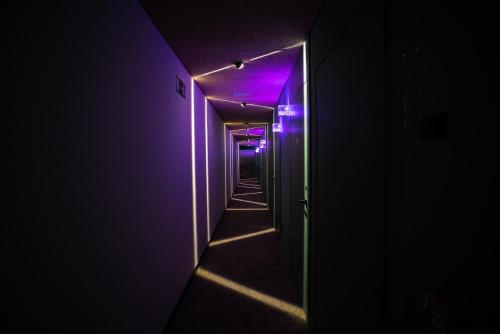 an empty corridor with purple lights in a hallway at Akeah Hotel Gran Vía in Madrid