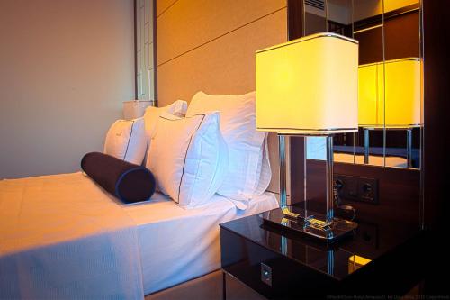 a bedroom with a bed with white pillows and a lamp at Northdoor Hotel in Amasra