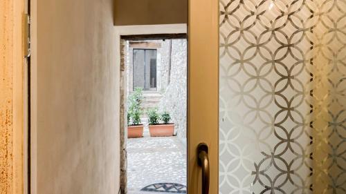 an open door to a courtyard with potted plants at Borgo San Valentino in Arrone