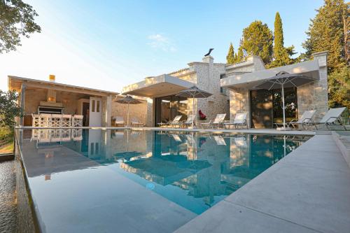 a swimming pool in front of a house at My Mediterranean Luxury Villas,Corfu in Kontokali