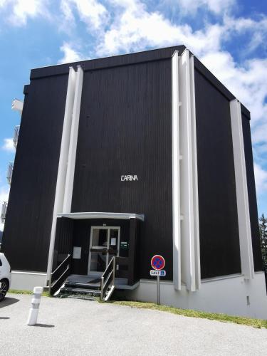 un edificio con un signo de sonido delante de él en Studio 2p, proche pistes, réduction matériel ski, en Chamrousse