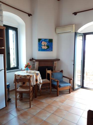a dining room with a table and chairs and a fireplace at Skardamoula's Studios and Apartments, 2 in Kardamili