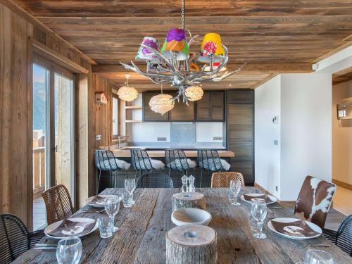 une salle à manger avec une table, des chaises et un lustre dans l'établissement Superbe appartement de 4 chambres au centre de Courchevel 1850, proche des pistes et commerces - FR-1-564-79, à Courchevel