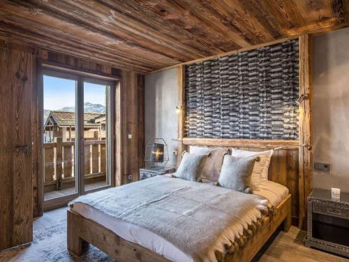 une chambre avec un grand lit et une grande fenêtre dans l'établissement Superbe appartement de 4 chambres au centre de Courchevel 1850, proche des pistes et commerces - FR-1-564-79, à Courchevel