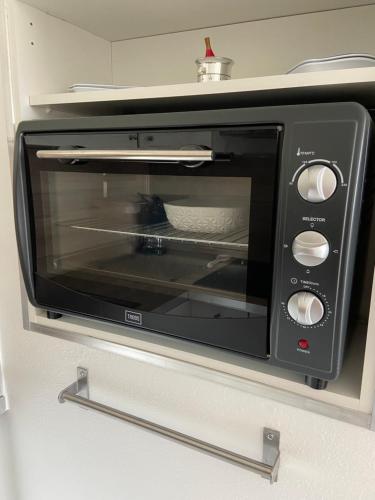 La cuisine est équipée d'un grille-pain noir et d'une porte ouverte. dans l'établissement Vue mer et verdure, à Villers-sur-Mer