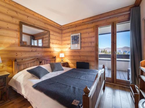 um quarto com uma cama num quarto com paredes de madeira em Appartement Courchevel 1850, 4 pièces, 6 personnes - FR-1-564-30 em Courchevel