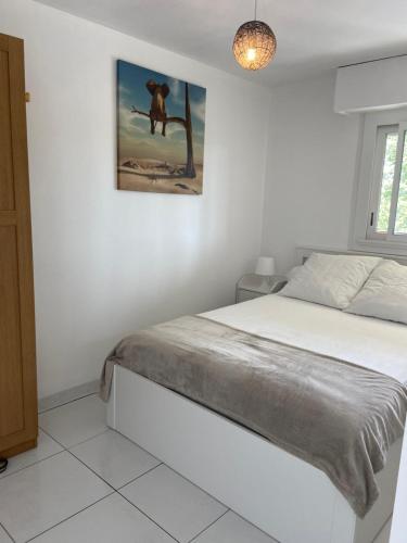 une chambre avec un lit et un tableau au mur dans l'établissement Vue mer et verdure, à Villers-sur-Mer