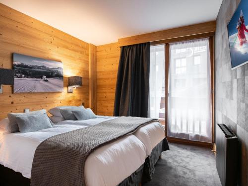 une chambre avec un grand lit et une grande fenêtre dans l'établissement Superbe Appartement 80m² pour 6 à Courchevel 1850 - 3 Chambres, Parking, Casier à Skis - FR-1-564-42, à Courchevel