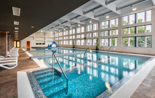 uma grande piscina com água azul num edifício em Hunguest Hotel Bál Resort em Balatonalmádi