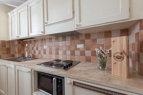 a kitchen with white cabinets and a stove top oven at Salvapiano Holiday Ranch in Riotorto