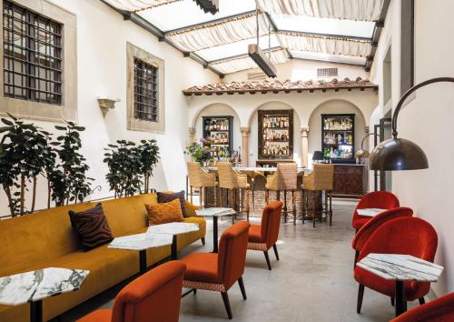 a room with a couch and chairs and a bar at Villa San Michele, A Belmond Hotel, Florence in Fiesole