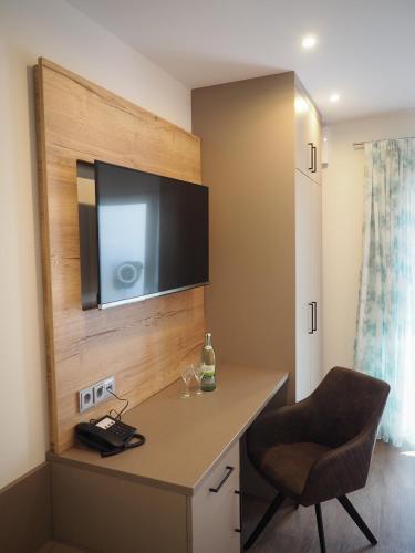 a room with a desk with a television on a wall at Landgasthof Zum Stern in Hammelburg- Obererthal