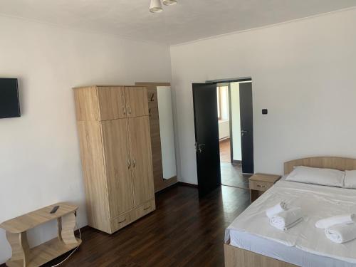 um quarto com uma cama e um armário de madeira em Pensiunea Alin em Siseştii de Sus