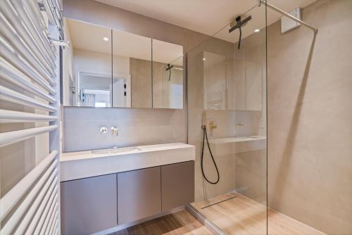 une salle de bain avec lavabo et douche dans l'établissement Rustig, comfortabel app op 50meter van het strand, à Coxyde