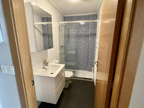 a bathroom with a sink and a toilet and a mirror at Estudio céntrico 1 con terraza y parking privado in Ourense